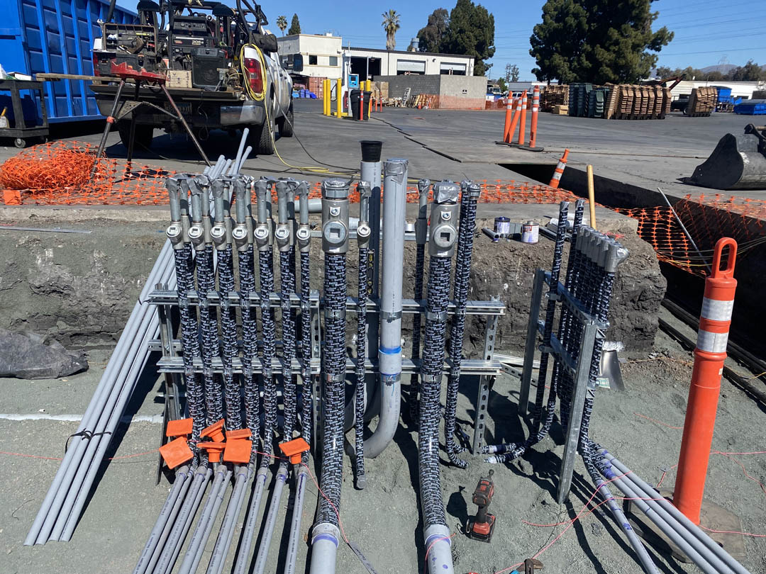 Parallel underground conduits entering an outdoor electrical equipment area