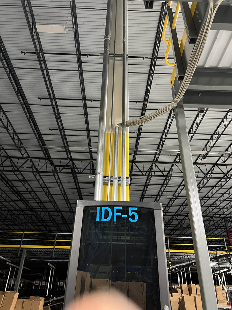 Warehouse column with vertical conduit runs and an electrical cabinet