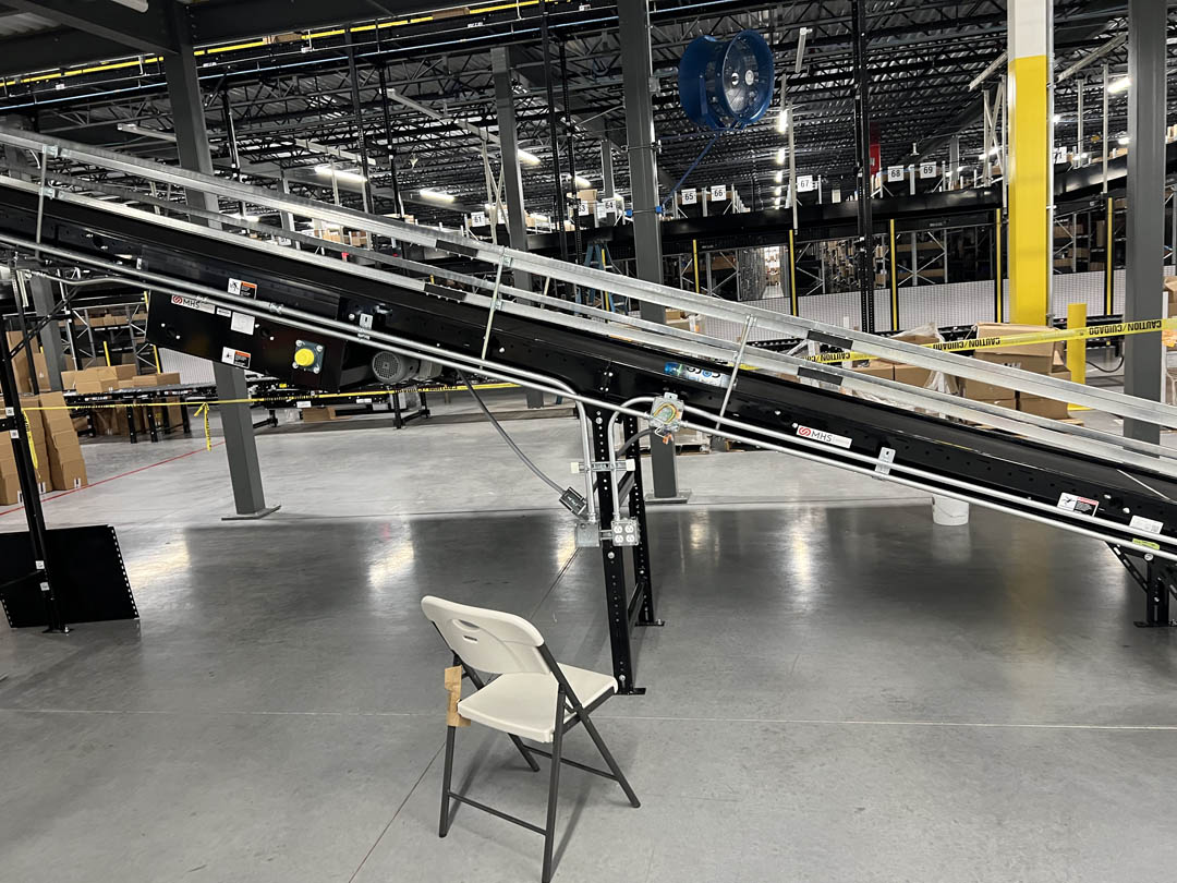 Conveyor section and equipment positioned on an open warehouse floor
