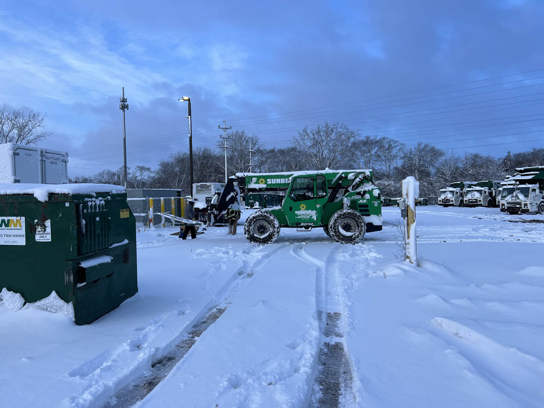 Snow-covered utility work area with site equipment and lighting