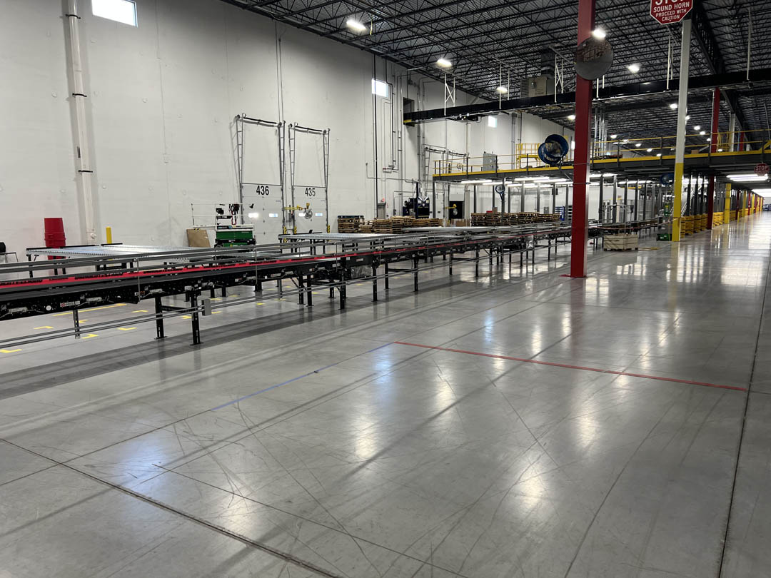 Conveyor line running across a polished warehouse floor