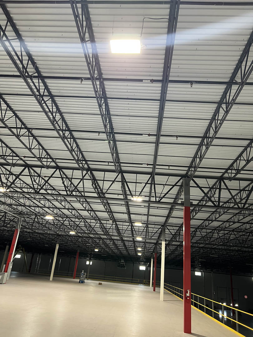 Open warehouse floor lit by rows of high-bay fixtures