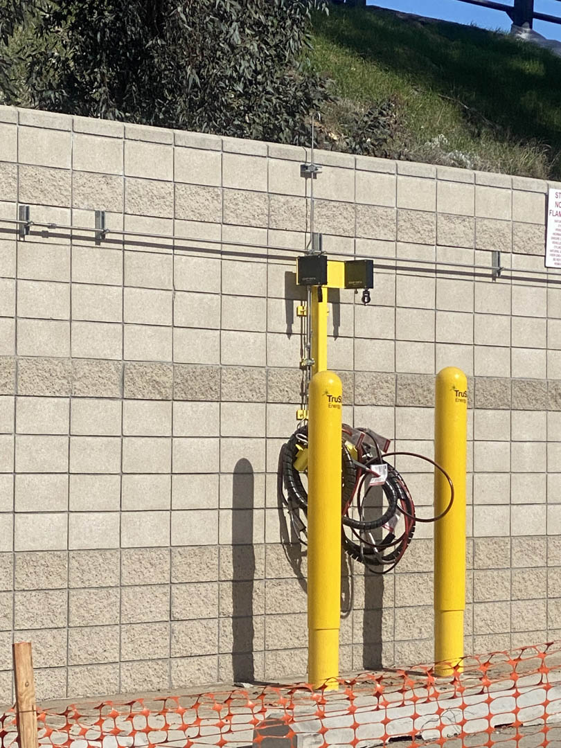 Wall-mounted electrical connection point protected by yellow bollards