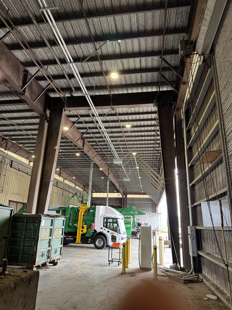 Overhead conduit and lighting above an EV charging area
