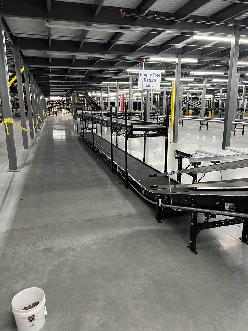 Conveyor equipment installed along a warehouse aisle