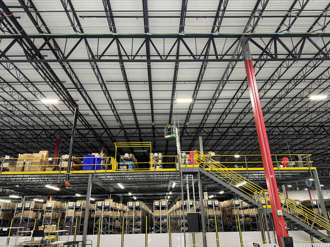 Warehouse lighting installed above conveyor equipment