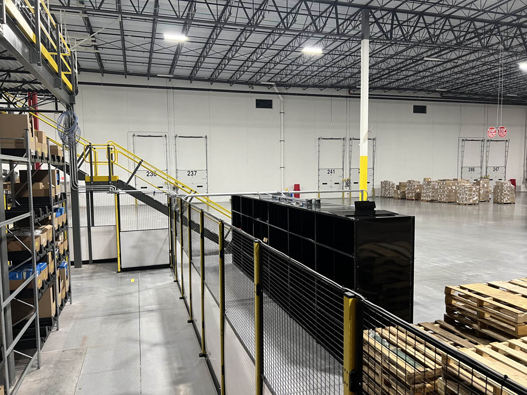 Long conveyor line behind safety fencing in a warehouse