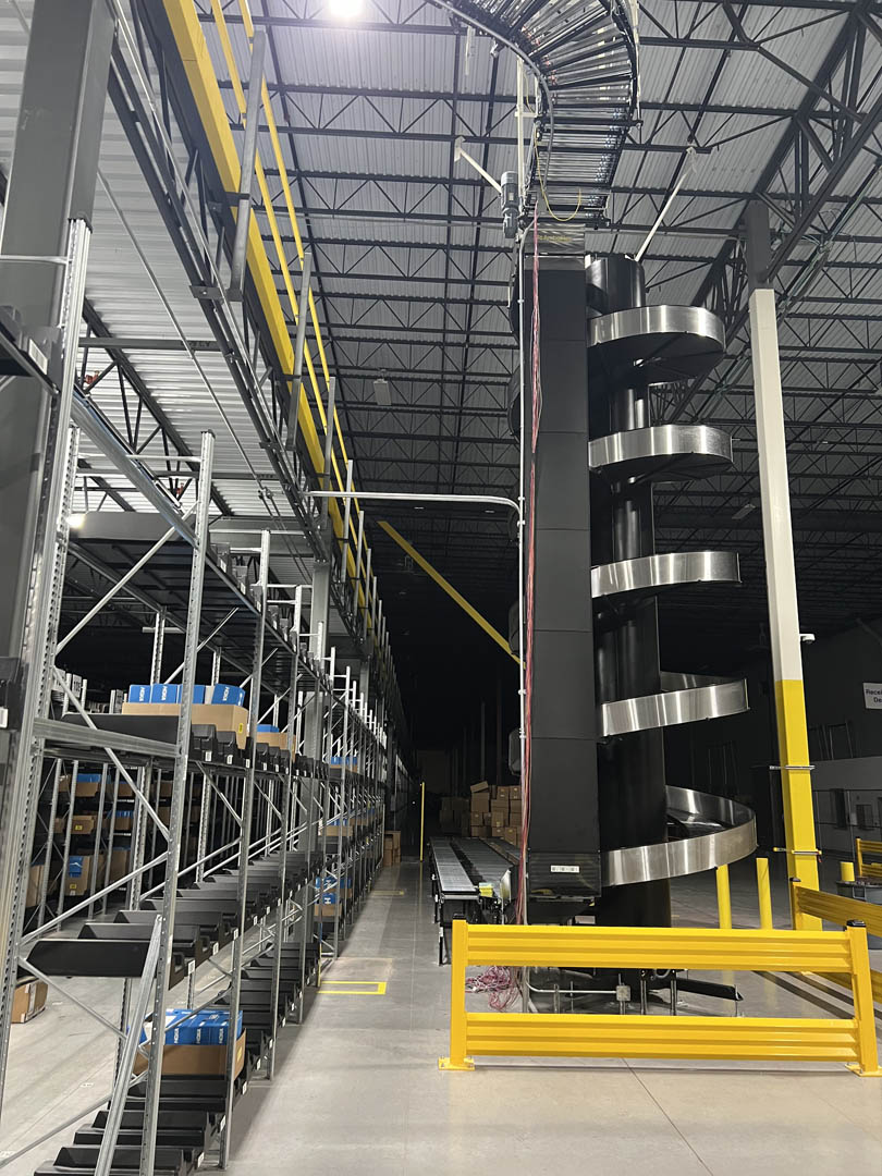 Spiral conveyor tower connected to elevated warehouse conveyor lines