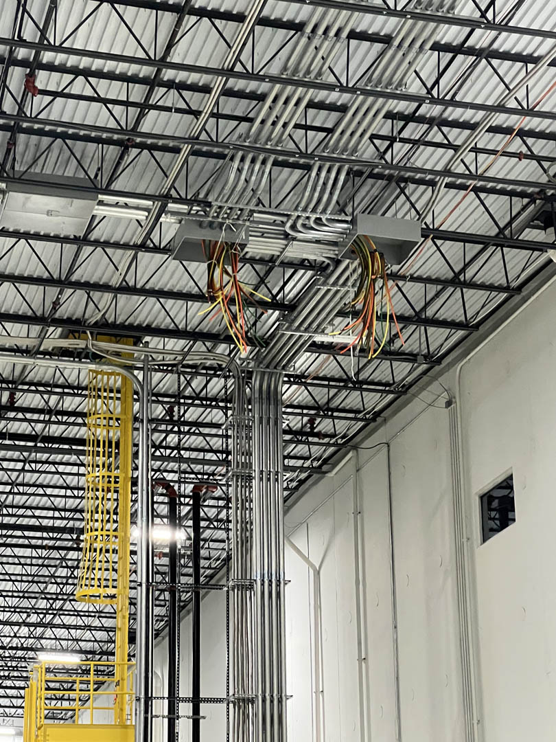 Lift positioned below overhead conduit and ceiling-mounted electrical work
